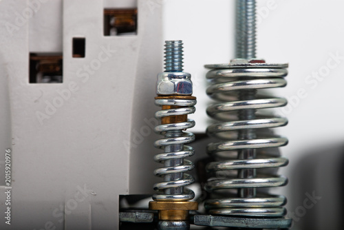 Tableau sur toile Disassembled industrial solenoid valve showing internal mechanism with powerful metal return springs, aluminum body with threaded port, and separate black protective cover