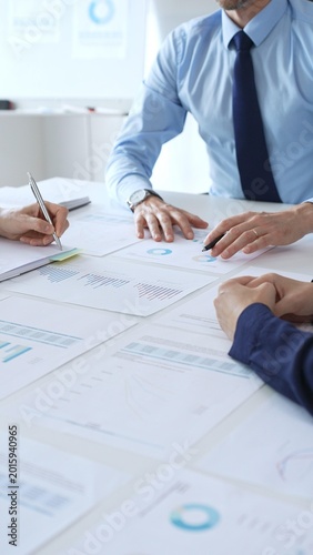 Business people team analyzing financial charts and graphs during corporate meeting, focusing on strategy development, data driven decision making