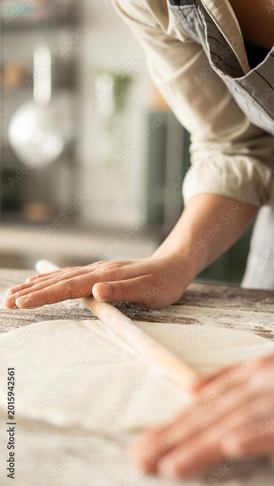Obraz premium Kneading dough at the kitchen table