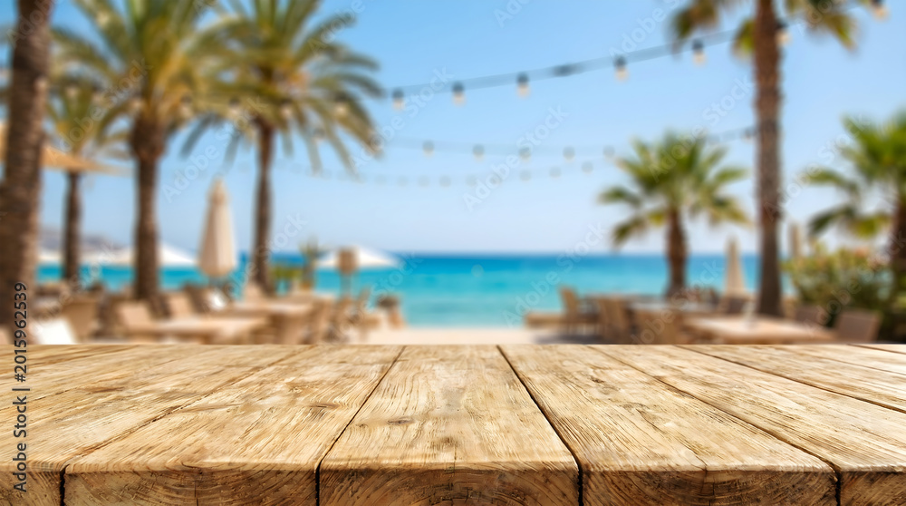 Fototapeta premium Empty wooden table with blurred tropical beach resort background for product display in summer vacation restaurant cafe.
