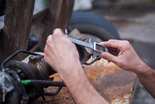 caliper in the hands of the master, measuring the dimensions of the part