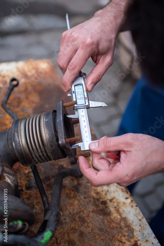 caliper in the hands of the master, measuring the dimensions of the part
