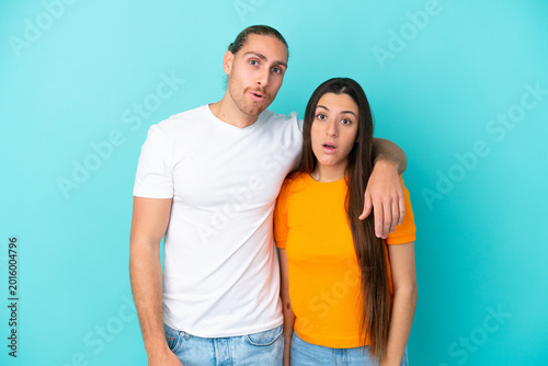 Canvastavla Young caucasian couple isolated on blue background with surprise facial expressi