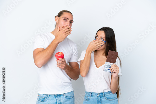 Photos Young caucasian couple with chocolat and apple isolated on white background cove