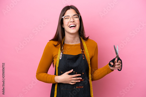 Foto Young Brazilian seamstress woman isolated on pink background smiling a lot