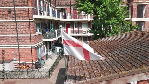 England Flags flying on roof.
London, England, United Kingdom - May 8 2026: Aerial drone footage of the Kirby Estate in Bermondsey, South London, showing large displays of England flags hanging fro