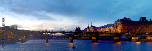 The panoramic night view of Seine river during the night with famous touristic bridge Pont des Arts, Paris, France.