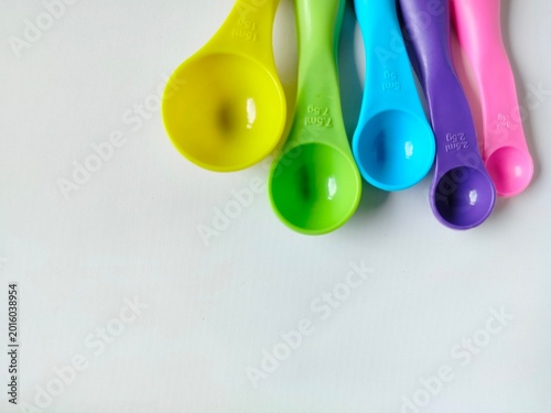 colorful plastic measuring spoon set with various sizes on white background