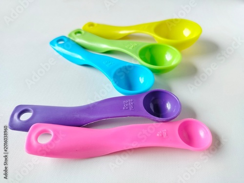 colorful plastic measuring spoon set with various sizes on white background