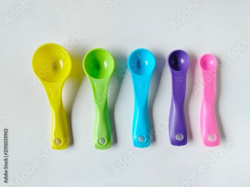 colorful plastic measuring spoon set with various sizes on white background