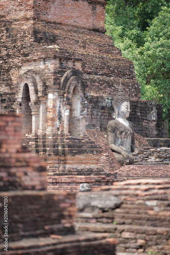 Vászonkép Perspective view of the standing ancient Buddha statue (Phra Attharot) in the mandapa, surrounded by chedis at Wat Mahathat, Sukhothai, Thailand