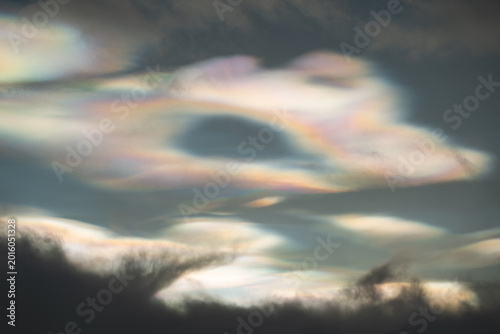 Rare iridescent nacreous cloud glowing in a pastel Arctic twilight sky above dark clouds, soft atmospheric winter scene in Norway