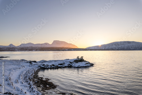 Relaxing on a snowy mountain viewpoint above Malangen Fjord