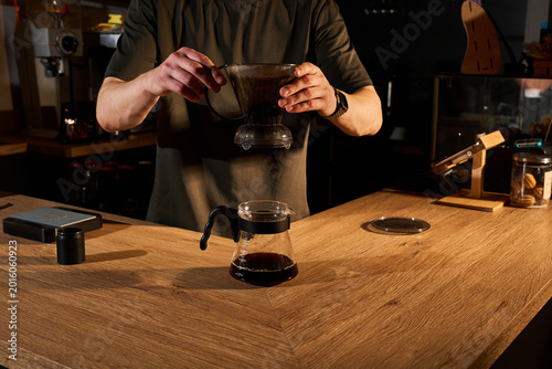 Photography Barista brewing specialty coffee using Clever Dripper and gooseneck kettle