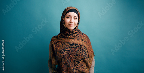 Fotografie Woman wearing a patterned headscarf and modest clothing, standing confidently ag