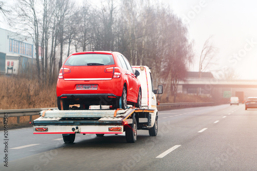 Schilderij op canvas Tow truck transporting red vehicle after breakdown