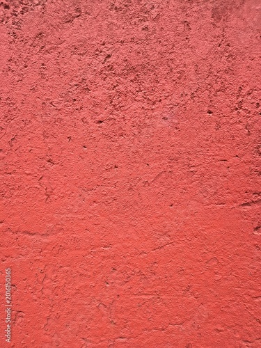 Red textured wall background featuring rough stucco plaster surface detail
