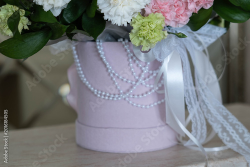 Photography Pink floral arrangement in a decorative hatbox with pearls and ribbons, featurin