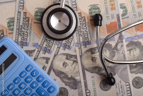 Stethoscope, calculator, and dollar bills representing healthcare costs, medical expenses, insurance planning, and hospital finance management concept.