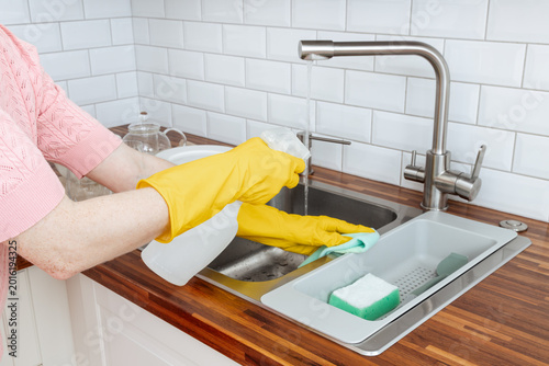 Foto A woman washing the sink in a kitchen