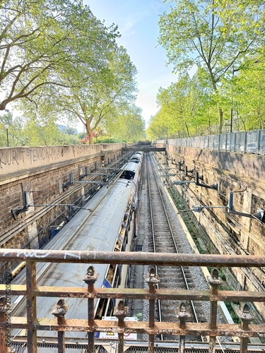 Obraz na płótnie vue sur un chemin de fer avec un train dans la ville de paris un jour de printem