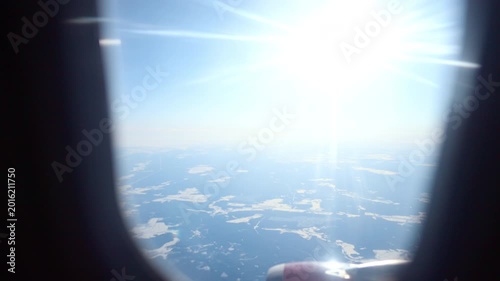 Sunshine Reflects On Icy Arctic Surfaces. Passenger Captures Landscape Of Icy Arctic With Clear Blue Sky. Glittering Sunlight Dances On Frozen Arctic Waters Seen From Airplane Window