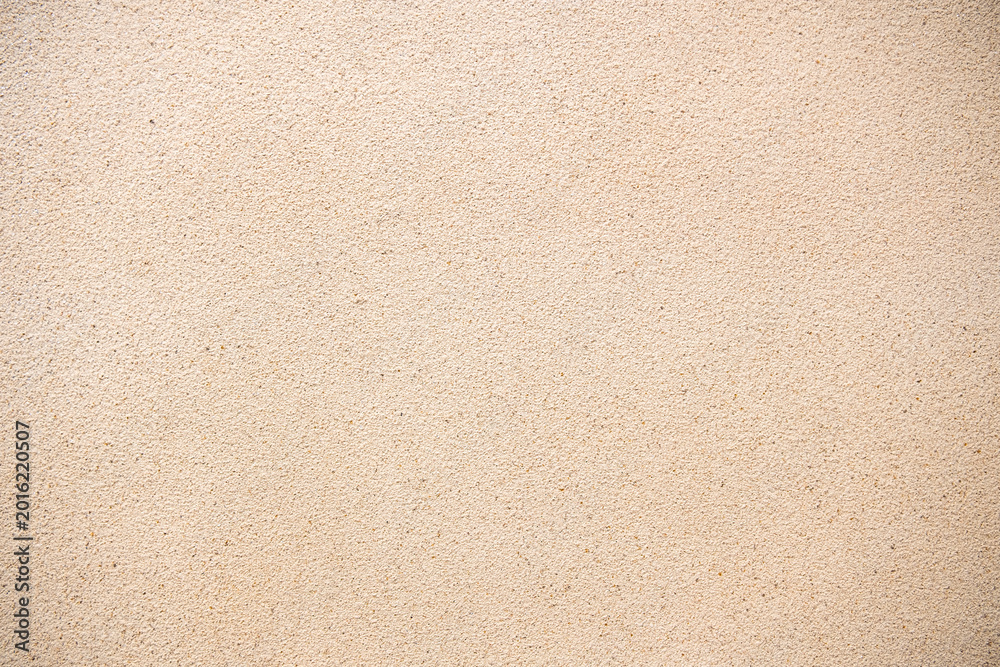 Fototapeta premium Beige sand wall texture background. Abstract grainy plaster surface for architectural design and construction backdrop. Natural light brown cement or stone finish with fine detailed material.