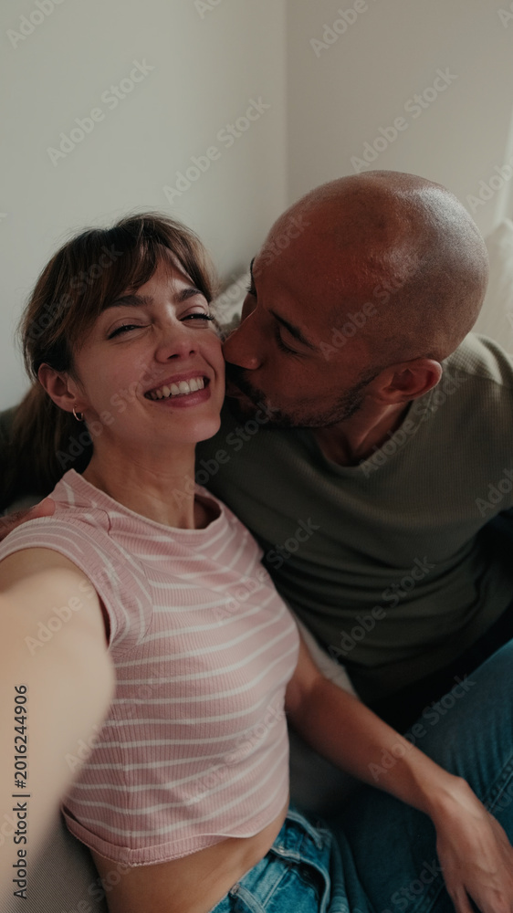 Fototapeta premium Couple At Home Laughing And Kissing