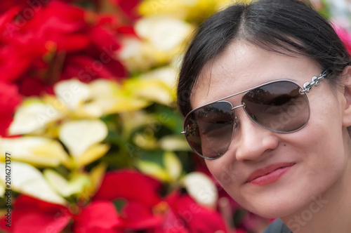 a happy chinese woman with red and white poinsettia christmas flower background