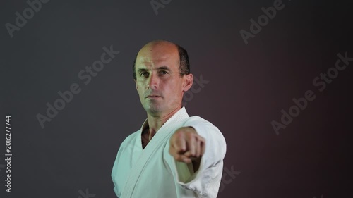 A young athlete practices punching against a multi-colored background with flashing lights