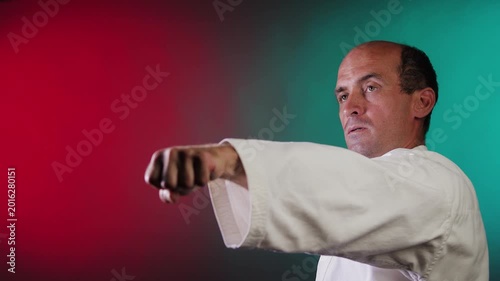 A young athlete throws punches against a multi-colored background with flashing red and green lights