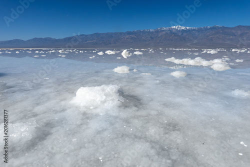 Reflection of sky on the flooded salt flats of Badwater Basin in Death Valley National Park.