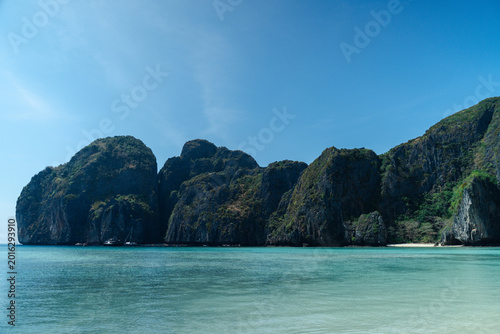 Foto Serene view of tropical beach with clear turquoise water and towering limestone