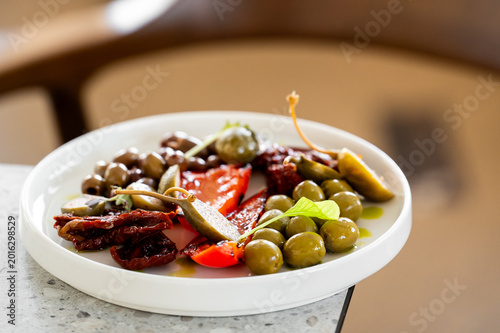 Bilde på lerret An assortment of Mediterranean appetizers on a white plate, featuring green and