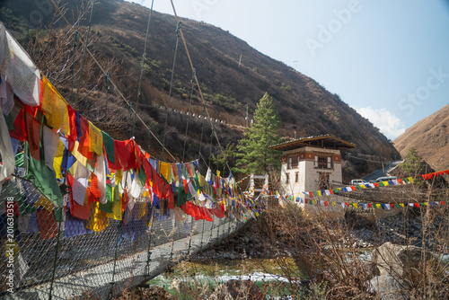 Tableau sur toile Tamchog Lhakhang, Traditional Bhutanese suspension bridge adorned with vibrant p