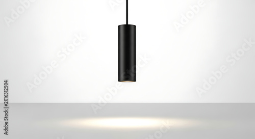 A contemporary black cylindrical pendant lamp provides focused illumination while suspended against a clean white background, perfect for architectural lighting concepts