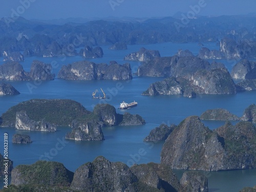 Vast limestone karsts rise from turquoise waters under clear blue skies