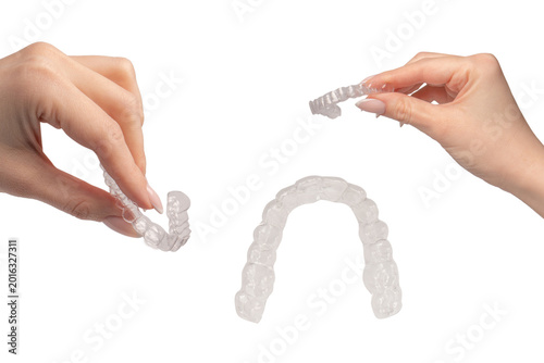 Transparent mouth guard in a woman's hand isolated.