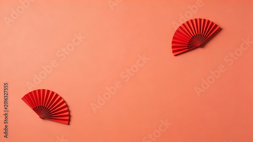 Red paper fans on orange background emphasizing fluid motion and vibrant color palettes