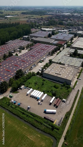 Industrial Aerial View: An expansive aerial perspective reveals a modern industrial complex, showcasing rows of warehouses and logistics infrastructure, highlighting the scale of commerce and trade.