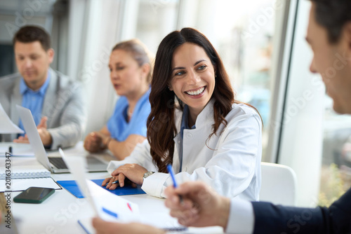 Quadro em tela Smiling female doctor cooperating with businessman  during a meeting  in a hospital