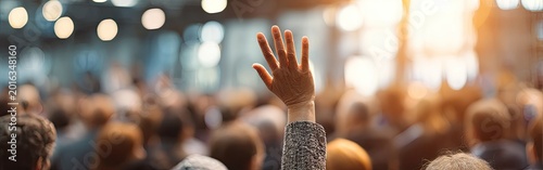 Person raising hand in crowd during daytime event