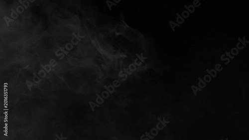 Abstract Wispy Smoke Drifting Slowly Across A Dark Black Background.