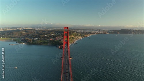 Centered drone view of Golden Gate Bridge with traffic and blue bay water