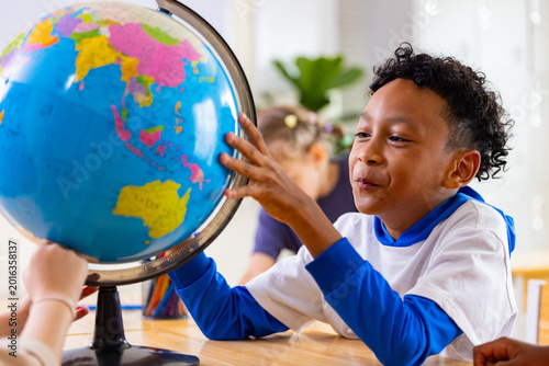 Foto Teacher and Students Learning Geography with Globe in Classroom