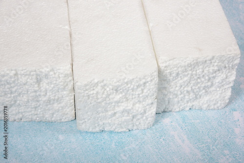 Polystyrene  pieces on blue background, Styrofoam texture, Packaging materials