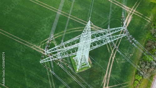 Aerial View of High Voltage Power Line Tower Over Green Agricultural Fields