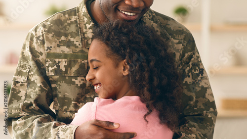Fotografía A soldier holds his daughter in a warm embrace as they reunite at a family gathering