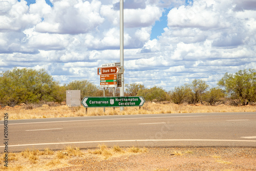 Road Signs Pointing to Carnarvon, Northampton, Geraldton and Shark Bay in the Australian Outback Under Cloudy Sky, Western Australia, 24 February 2023