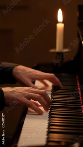 Playing piano beside a candle at night in a quiet room